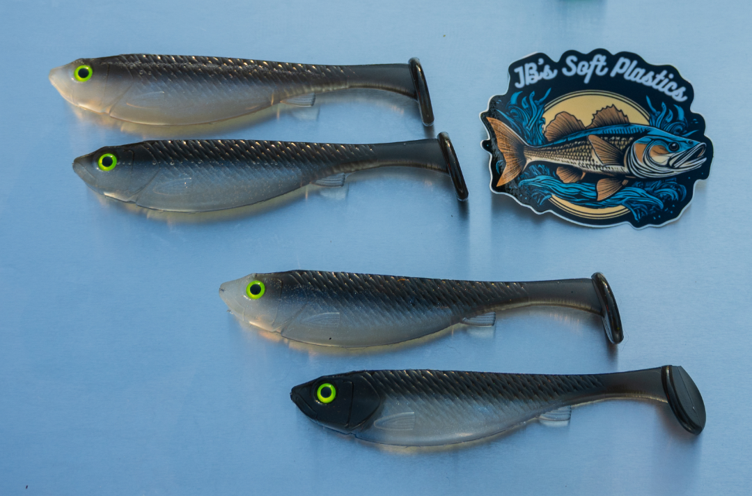 Set of soft plastic fishing lures on a white surface with a brand logo.